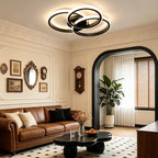 Novoora modern LED ceiling light with interlocking circular rings in a stylish living room with brown leather sofa.
